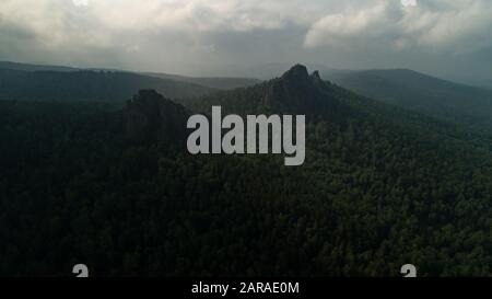 Riesige Steinsäulen vom Berg. Orangefarbene Morgensonne. Filmische Luftdrohne Flug Drift. Schöne beste russische Natur Stockfoto