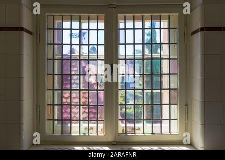 Altes weiß lackiertes Holzfenster mit dicken Glasleisten Stockfoto