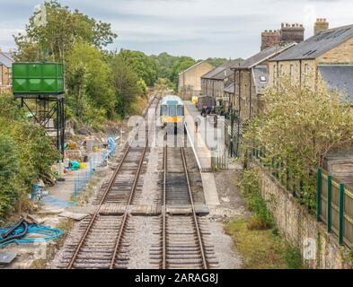 Personenzug auf den Gleisen am Bahnhof Leyburn, mit Menschen auf dem Bahnsteig. Leyburn, Richmondshire, North Yorkshire, England, Großbritannien. Stockfoto