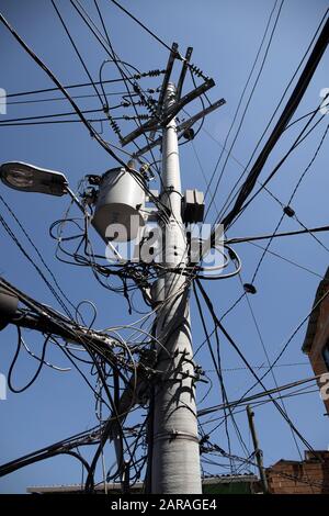 Medellin: Comuna 13, heute ist das Gebiet für die Graffiti-/Straßenkunst bekannt, die dazu beigetragen hat, dieses Gebiet zu verändern. Stromversorgung über Oberleitungen. Stockfoto