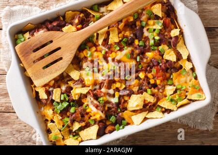 Frisch gebackene Frito-Pastete mit gemahlenem Rindfleisch, Käse, Mais, Bohnen und Pommes in einer Backform auf dem Tisch. Horizontale Draufsicht von oben Stockfoto