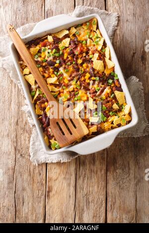 Traditionelle Frito-Pastete mit gemahlenem Rindfleisch, Käse, Mais, Bohnen und Pommes in einer Backform auf dem Tisch. Vertikale Draufsicht von oben Stockfoto