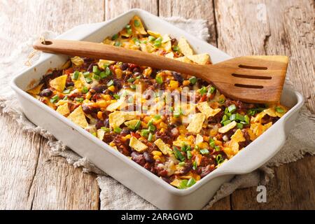 Knusprige hausgemachte Frito-Pastete mit Rind, Käse, Mais, Bohnen und Pommes in einer Backform auf dem Tisch. Horizontal Stockfoto