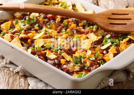 Rezept für einen köstlichen Frito-Kuchen mit gemahlenem Rindfleisch, Käse, Mais, Bohnen und Pommes in einer Backform auf dem Tisch. Horizontal Stockfoto