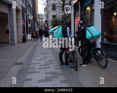 Fahrer, die auf Food City of London warten, warten auf die Lieferung von Fahrrädern von Deliveroo Stockfoto