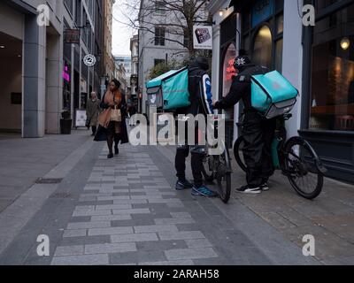 Fahrer, die auf Food City of London warten, warten auf die Lieferung von Fahrrädern von Deliveroo Stockfoto