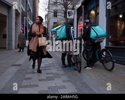 Fahrer, die auf Food City of London warten, warten auf die Lieferung von Fahrrädern von Deliveroo Stockfoto