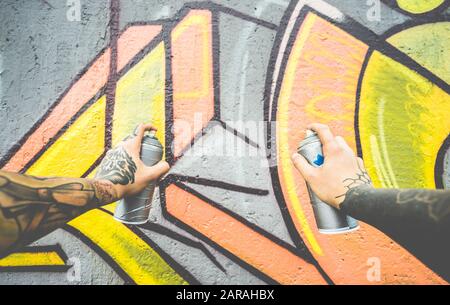 Graffiti-Künstler-Malerei mit Farbspray an der Wand - Tattoed Writer at Work in Suburb Neighbourhood - Urban, Street Art, Millennials Generation, Mur Stockfoto