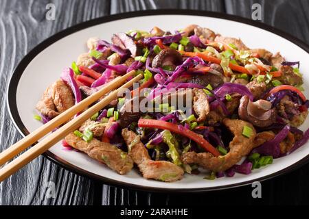 Chinesische Küche Schweinefleisch moo shu mit Gemüse und Pilzen in einem Teller auf dem Tisch. Horizontal Stockfoto