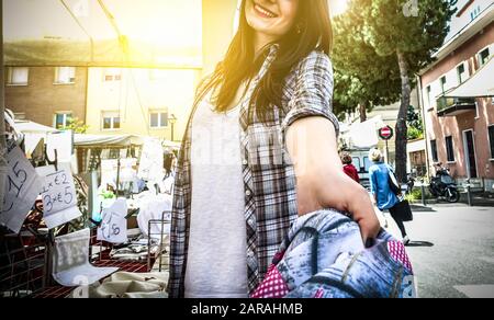 POV-Ansicht der jungen weiblichen Verkäuferin, die auf dem Wochenmarkt im Sommer kurze Jeans in der Kleidung gibt - Fröhlicher Verkaufsmitarbeiter, der in der zweiten Hand arbeitet, sticht hervor Stockfoto