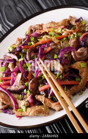 Heißes chinesisches Schweinefleisch moo shu mit Gemüse in einer Platte auf dem Tisch. Vertikal Stockfoto