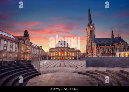 Chemnitzer, Deutschland. Stadtbild von Chemnitzer Oper und Petrikirchkirche bei schönem Sonnenuntergang. Stockfoto