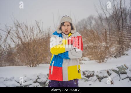 Der Mann war im Winter bei Schneefall sehr gefroren. Winterprobleme Stockfoto