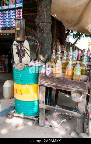 Ein strassenrand Shack mit Kraftstoff für Motorräder mit Flaschen aus einem Fass gefüllt. Benzin ist in das Fahrrad aus der Flasche gegossen. Kampot, Kambodscha. Stockfoto
