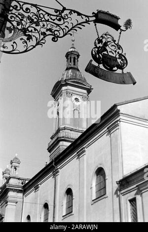 Kneipenschild Höllbräu mit dem Turm der St. Oswald-Kirche, 1957. Kneipschild Höllbräu mit St. Oswalds Kirchturm, 1957. Stockfoto