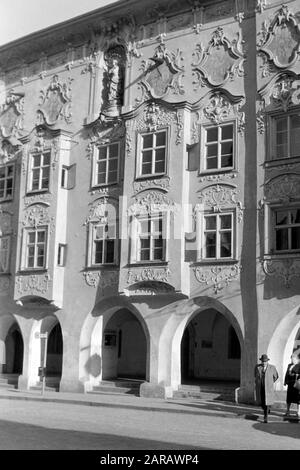 Das Kernhaus mit Rokoko-Fassade von Stuckateur Johann Baptist Zimmermann, heute behertert der rechte Teil das Hotel und Gasthaus Paulanerstuben, der linke das Amtsgericht Wasserburg, 1957. Das Kern-Gebäude zeigt eine von dem Stuck-Pflasterer Johann baptist Zimmermann gestaltete Rokoko-Fassade, die heute als Hotel und Restaurant Paulanerstuben im rechten Flügel und als Amtsgericht im linken Flügel, 1957, dient. Stockfoto