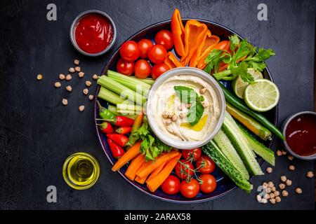 Hummus platter mit verschiedenen Snacks. Hummus in der Schüssel und Gemüse Sticks. Platte mit dem Nahen Osten. Partei, Finger Food. Ansicht von oben. Vegan, Hummus dip Stockfoto