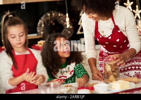Mädchen helfen Mutter, Plätzchen für Weihnachten zu machen Stockfoto
