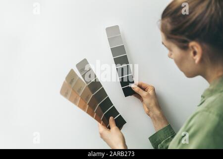 Innenarchitekt wählt die Farbe der Wandfarbe aus den Proben aus Stockfoto