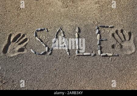 Das Wort Verkauf auf dem Sand Stockfoto