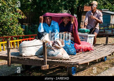 Zwei Kambodschaner lächelnd und bergende unter ein Blatt mit Ware auf einem Bambus-Zug Haltestelle O Sra Lav Stockfoto