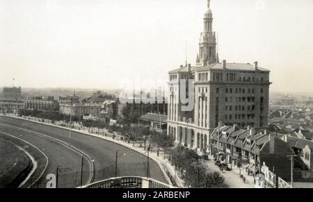 Rennbahn und Bubbling Well Road, Shanghai, China, mit China United Apartments und dem YMCA im Bau. Stockfoto