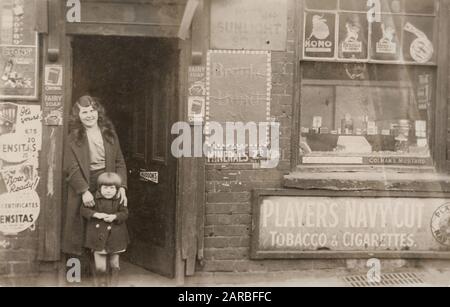 Frau und Mädchen vor einem Laden, Handsworth, Birmingham. Stockfoto