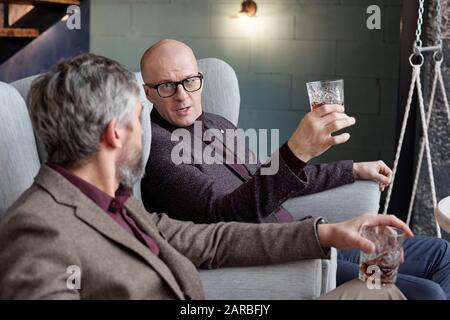 Besprechung der Geschäftsabläufe über ein Glas Whisky Stockfoto