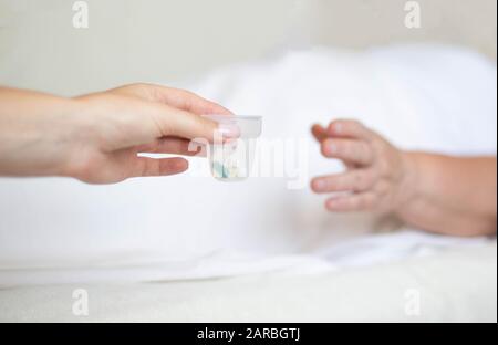 Doktor hält Anti-Hypertonie-Pillen und Antidepressiva für eine ältere Frau, Kapsel Klassifizierungskonzept Stockfoto