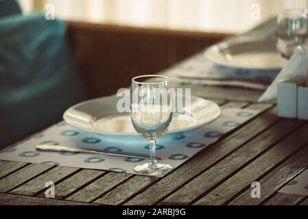 Leere geschirr Tisch im Restaurant mit Glas und Platte, Sommer romantischen Stil in blau und braun Farben Stockfoto