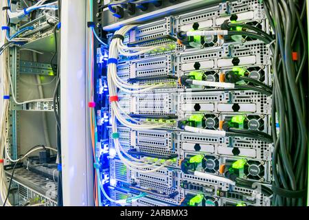 Viele Kabel verbinden sich mit den Netzwerkschnittstellen leistungsstarker Internetserver. Racks mit Computerausrüstung im Serverraumzentrum. Netzwerkrouter Stockfoto