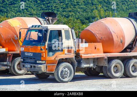 Betonwagen auf der Baustelle. Autos sind nicht neu, die staubigen und platzgedrungenen. Stockfoto