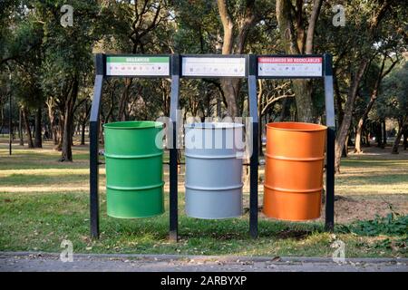 Drei große Abfallbehälter für die selektive Müllabfuhr in einem Stadtpark in Mexiko, in den Farben der Nationalflaggen. Stockfoto