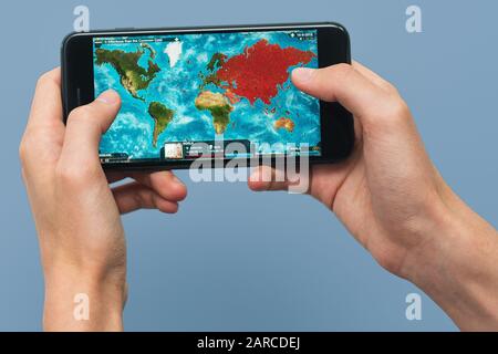 Samara, Russland -07, 29, 2019: Hände halten ein Smartphone Iphone 8 Plus mit Plague Inc: Entwickeltes Spiel auf dem Bildschirm, Illustrative Editorial. Stockfoto