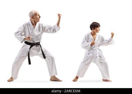 Lange Aufnahme eines Jungen und eines älteren Mannes in Kimonos Üben Karate isoliert auf weißem Hintergrund Stockfoto