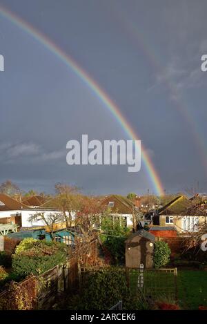 Ein Regenbogen bildete sich über den Dächern von Vorstadthäusern in Shepperton Surrey England UK Stockfoto