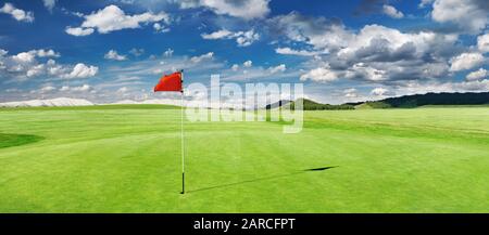 Panorama des Golfplatzes mit roter Flagge in einem Loch Stockfoto