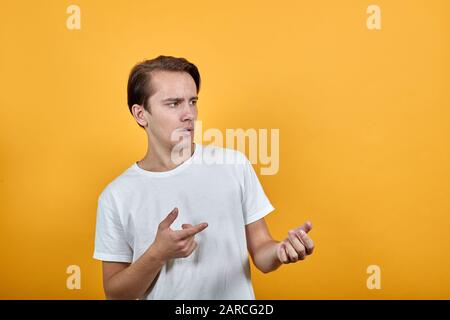 Der junge Mann blickt überraschend davon und hebt sich die Hände. Stockfoto