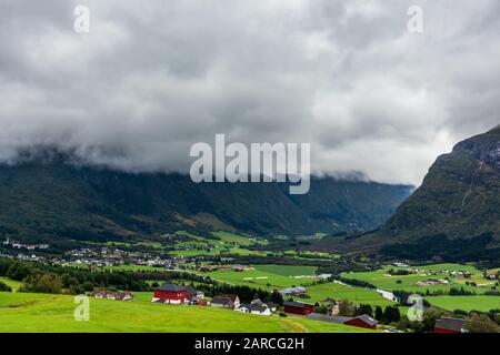 Grüne Rasenfelder in Norwegen auf dem Land in der Nähe von Bergen. Bewölkt nebliger Sommertag, ländliche landschaft norwegens. Stockfoto