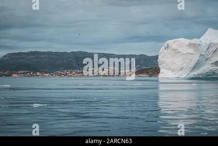 Grönlandgletscher mit Meereis und riesigem Eisberg vor der arktischen Stadt Ilulissat. Gletscherlandschaft in der Nähe des berühmten Icefjord im Westen grönlands Stockfoto