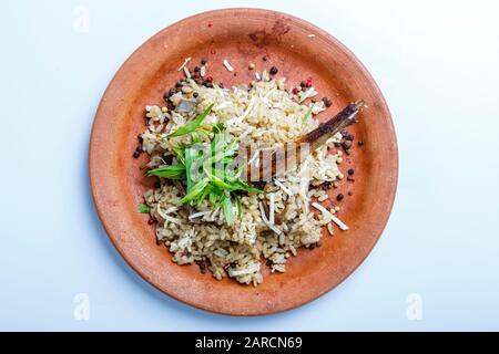 Lammrippe mit Reis auf einer Tonplatte, auf weißem Grund Stockfoto