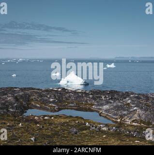 Magische Arcticlandscape am Arktischen Ozean in Grönland. Eisberge schwimmen im Wasser. Blauer Himmel an einem Sommertag. Stockfoto