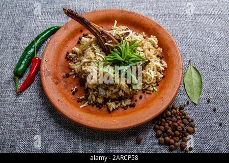 Lammrippe mit Reis auf einer Tonplatte. Strukturierte graue Leinwand Stockfoto