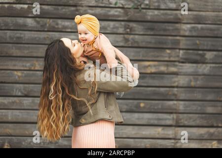 Unglaublich schöne Mutter Holding in die Arme ihrer Tochter und außerhalb zu küssen. Modischen Look. Stockfoto