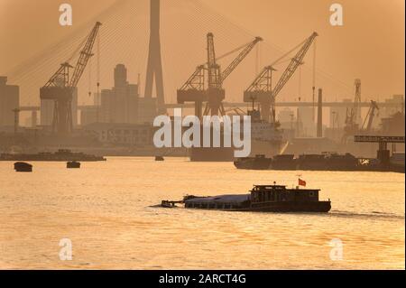 Überlasteter Kahn, der in Shanghais Hafen eindringt.Natürliches Licht sieht aber aus wie ein b&w-Effekt. Stockfoto