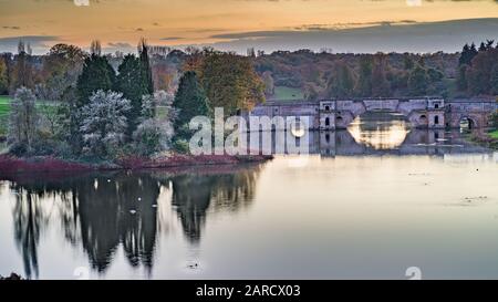Eine Landschaft, die zur Dämmerung gedreht wurde und eine alte Brücke in der Nähe des Blenheimer Palastes zeigt, eine schöne Landschaft und ein Gefühl von Ruhe und Frieden bei dieser Aufnahme Stockfoto
