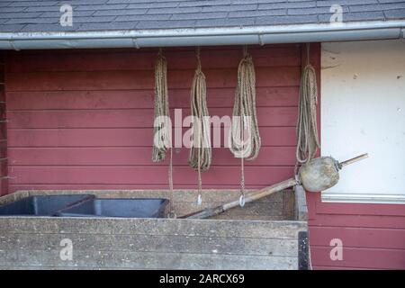 Ein Wagen vor einem Fischerhaus. Über dem Wagen hängen Seile und Fischernetze. Stockfoto