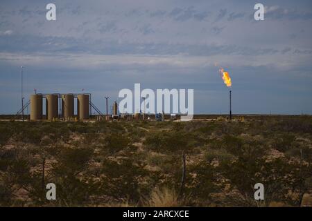 Permian Basin Gas Flare - das Brennen von überschüssigem Erdgas an einem Rohöllagerplatz ist eine gängige Praxis, wenn die Gaspreise es für unwirtschaftlich halten. Stockfoto