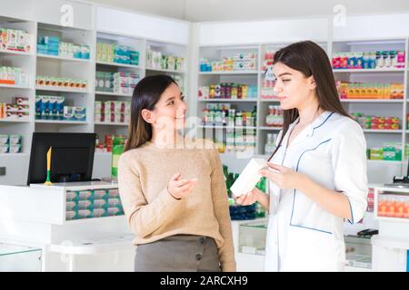 Zufriedener Kunde. Professionelle Beratung in der Apotheke. Selbstbewusster Apotheker berät einen Kunden über ein Produkt in der Apotheke Stockfoto