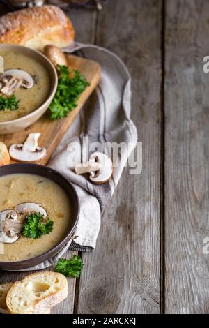 Köstliches hausgemachtes Suppenpüree mit portobello und Wildpilzen auf rustikalem Tisch. Copyspace Hintergrund. Stockfoto